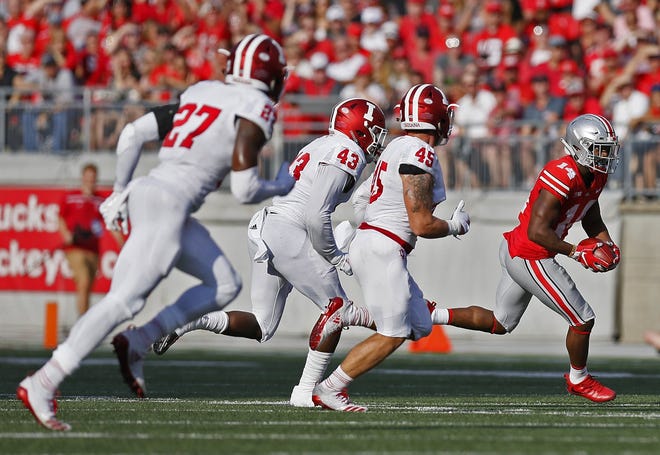 K.J. Hill tries to elude a trio of Indiana defenders in the second quarter. The OSU receiver had four catches for 46 yards. [Eric Albrecht/Dispatch]