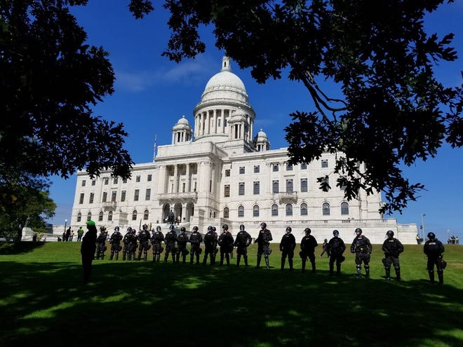 Riot police stand on the lawn of the Rhode Island State House in Providence Saturday afternoon. [The Providence Journal / G. Wayne Miller]