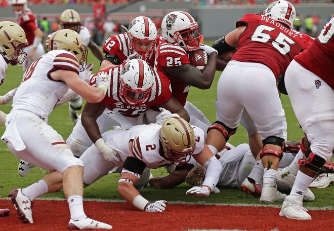 North Carolina State's Reggie Gallaspy II (25) scores a touchdown as State's Joshua Fedd-Jackson (66) blocks Boston College's Zach Allen (2) during the first half in Raleigh on Saturday. N.C. State won 28-23. [AP Photo/Gerry Broome]