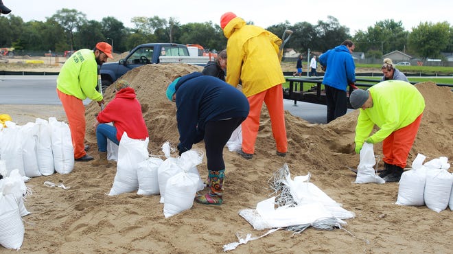Winnebago County Jail inmates and local residents fill sandbags for flooded areas Sunday, Oct. 7, 2018, in Machesney Park. [CHRIS NIEVES/RRSTAR.COM CORRESPONDENT]