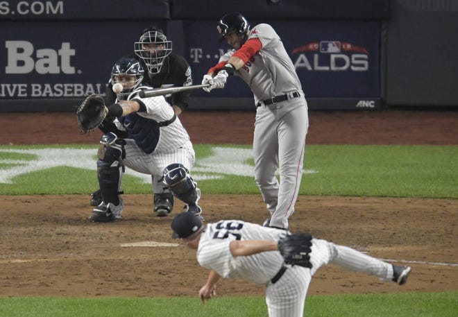 Boston's J.D. Martinez singles to center to drive in a run during the seventh inning of Monday's ALDS Game 3 rout of New York at Yankee Stadium. [Bill Kostroun/AP]