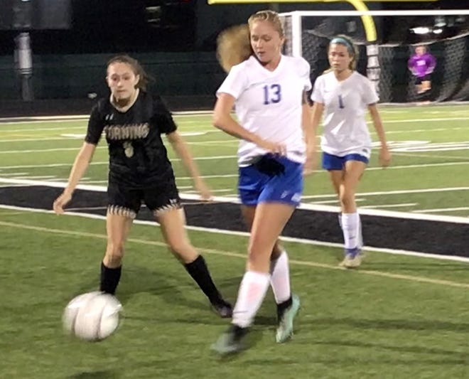 Horseheads' Kendall Murray looks to keep the ball in play as Corning's Alexis Johns defends. [THE LEADER STAFF]