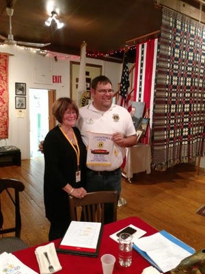Kathryn Woodlock, president of the Palmyra-Macedon Lions Club, exchanges a banner with District Gov. William Brown. [PHOTO PROVIDED/BONNIE HAYS]