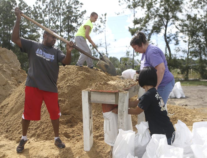 From left, Haskel Johnson, Daniel Tippett, Jennifer Tippett and Nobuko Johnson fill sand bags at the Lynn Haven Sports Complex in Lynn Haven on Monday as they prepared for Hurricane Michael. Lynn Haven is in Bay County in the Florida Panhandle. [Patti Blake /News Herald via AP]