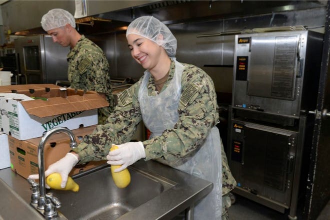 IS2 Shea Duarte-Whalen, assigned to the "Fighting Tigers" of Patrol Squadron 8, washes yellow squash during a community relations event at the Sulzbacher Center. VP-8 Sailors prepared and served food to members of the downtown Jacksonville community in need.