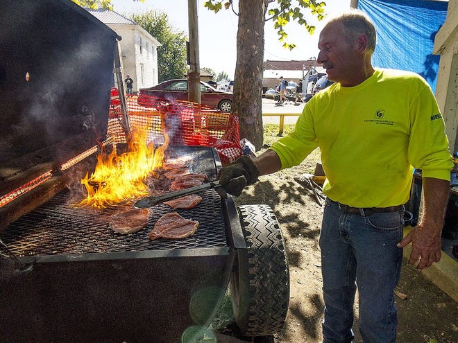 FILE: Chris Girard mans the grill at the London Mills Fire Department food stand during the Spoon River Scenic Drive. [STEVE DAVIS/The Register-Mail]