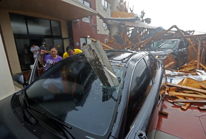 A woman checks on her vehicle as Hurricane Michael passes through, after the hotel canopy had just collapsed, in Panama City Beach, Fla., Wednesday, Oct. 10, 2018. (AP Photo/Gerald Herbert)