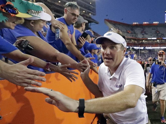 Florida head coach Dan Mullen celebrates with fans as he leaves the field after defeating fifth-ranked LSU on Saturday in Gainesville. [AP Photo/John Raoux]