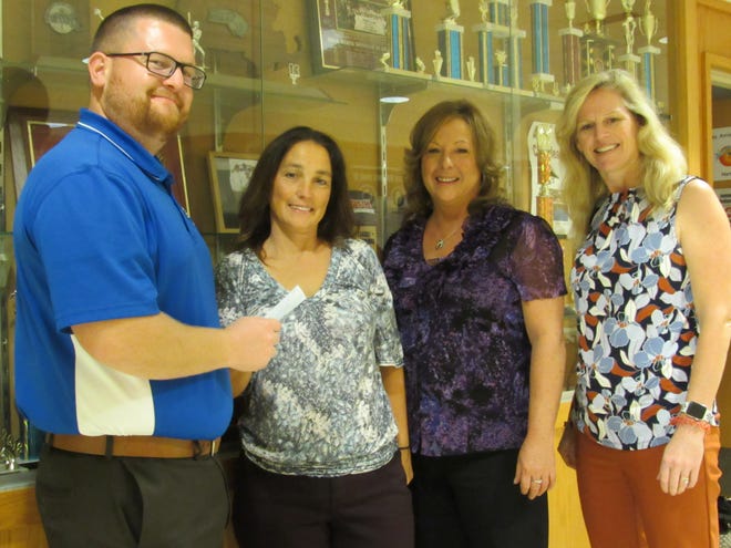 Millbury High School Athletic Director Pat Mara, far left, receives a donation on Thursday, Oct. 11, from Ann Marie Wysote and Christine Schold. The funds were collected during the annual Michael Schold, Jr. motorcycle ride on July 14. At far right is MHS Principal Tara Bennett. [Photo by Robert Fucci]