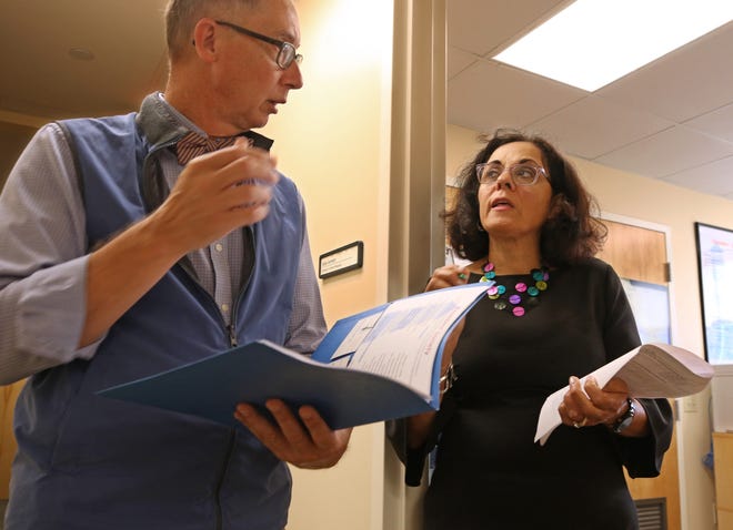 Marie Ghazal, chief executive officer of the Rhode Island Free Clinic, consults with Marvin Ronning, director of strategic partnerships. The clinic, on Broad Street in South Providence, sees over 2,400 uninsured Rhode Islanders. That's 7,000 visits a year — all for free. [The Providence Journal / Steve Szydlowski]