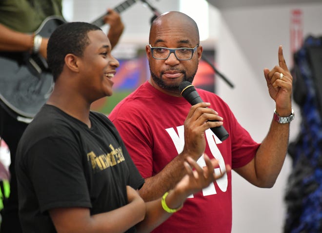 Award-winning author and poet Kwame Alexander, right, challenges Booker Middle School student Keenan Howell to complete words of a poem. Alexander spoke to students from Booker, Riverview and Venice High Schools and Booker Middle School at Selby Public Library on Thursday for “Teen Read Week.” [Herald-Tribune staff photo / Mike Lang]