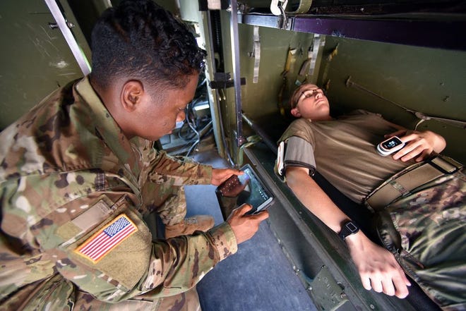 Spc. Nathaniel Coleman, 690th Ground Ambulance Company, 28th Combat Support Hospital, 44th Medical Brigade, demonstrates the Medical Hands-free Unified Broadcast (MEDHUB).
