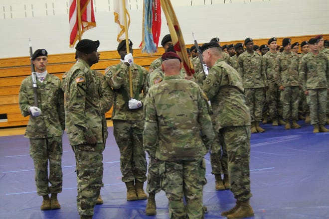 Brig. Gen. Christopher Mohan (far right), outgoing commander of the 3rd Expeditionary Sustainment Command, prepares to pass the colors that are handed to promotable Col. James Smith (far left, incoming commander of the 3ESC, during a change of command ceremony Friday, Oct. 12, 2018, at Fort Bragg's Hercules Fitness Center. [Rachael Riley/The Fayetteville Observer]