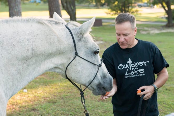 Chaplain (Maj.) Jeffery Masengale, Fort Bragg garrison chaplain, feeds his horse Cody carrots during the Blessing of the Pets ceremony at Pope Chapel Oct. 4.