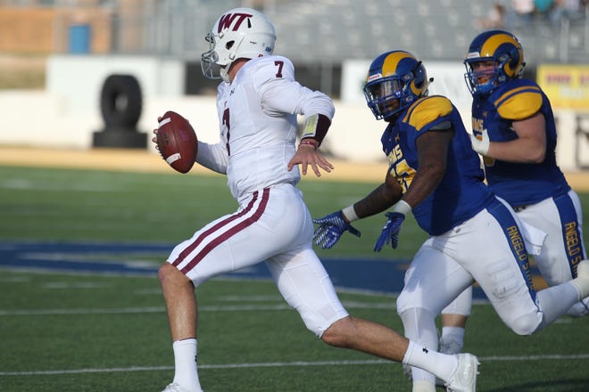 West Texas A&M quarterback Justin Houghtaling fights for yardage against Angelo State during a Lone Star Conference game at LeGrand Stadium at 1st Community Credit Union Field on Saturday. [Charles Bryce/ For the Amarillo Globe-News]