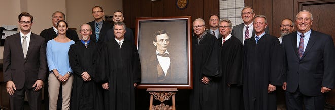 Past and present judges of Stephenson County, as well as local and state political figures, pose next to a photograph of Abraham Lincoln after its unveiling Sept. 26, 2018, at the Stephenson County Courthouse in Freeport. [PHOTO PROVIDED]