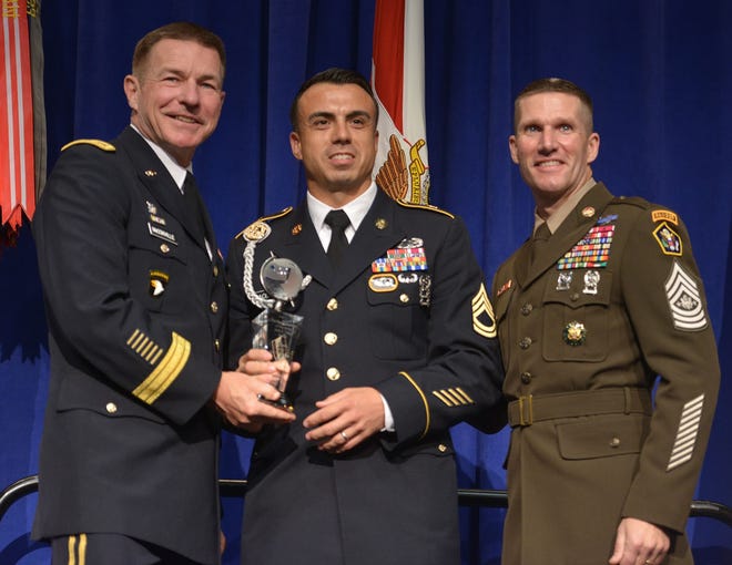 Sgt. 1st Class Sean Acosta accepts the NCO of the Year award on Oct. 8. [Joe Lacdan/U.S. Army]