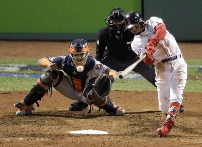 Boston Red Sox batter Mookie Betts hits a RBI double against the Houston Astros during the eighth inning in Game 2 of the American League Championship Series on Sunday at Fenway Park. [Photo by AP]