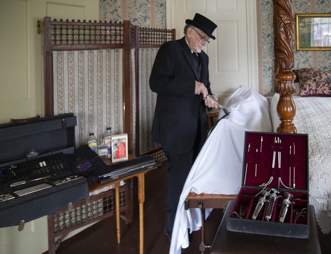 Ron Deighan, 76, of Pawtucket plays the undertaker at the Hearthside House Museum exhibit "Death and Mourning in the Victorian Age." The Lincoln museum's exhibit shows visitors how the undertaker set up in the master bedroom when Simon E. Thornton, one of the house's owners, died in 1873. [The Providence Journal / Donita Naylor]