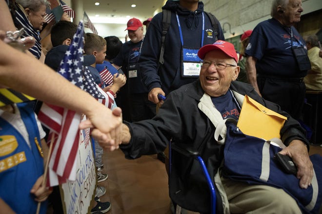 Sy Levenstein, of Wellington, a Korean War veteran, shakes Anna Robinson's hand as he returns from Washington D.C. on the Southeast Florida Honor Flight to a crowd of hundreds at the Palm Beach International Airport in West Palm Beach on Oct. 13, 2018. The Honor Flight took about eighty veterans to D.C. on the fourth and final one-day trip of the year. This was the first trip to include Vietnam veterans as WWII and Korean War veteran numbers wane. (James Wooldridge /pbpost.com)