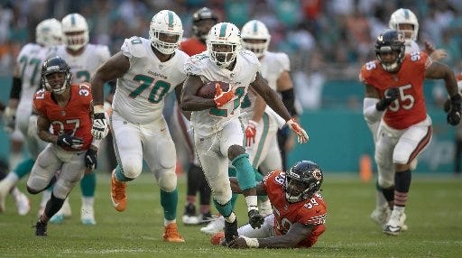 Dolphins running back Frank Gore breaks away from the Chicago defense thanks to his offensive line. (Allen Eyestone / The Palm Beach Post)