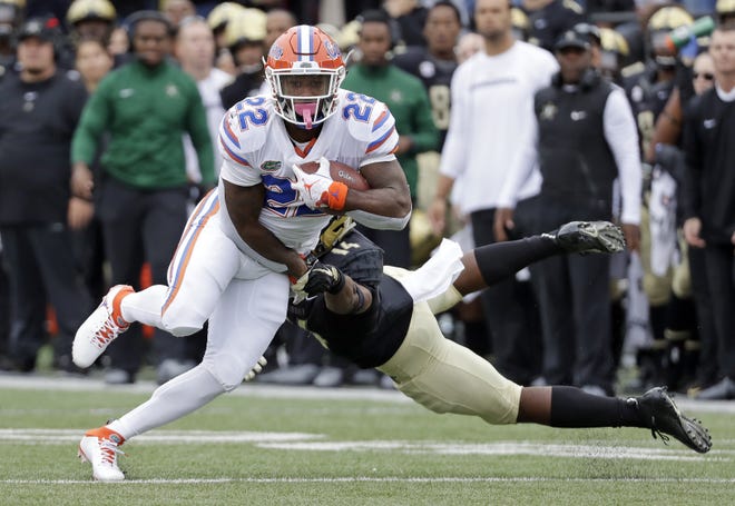 Florida running back Lamical Perine gets past Vanderbilt defensive back Max Worship (14) in the first half Saturday in Nashville, Tenn. Perine added a TD run and 121 yards rushing to the Gators' attack. [Mark Humphrey/AP]