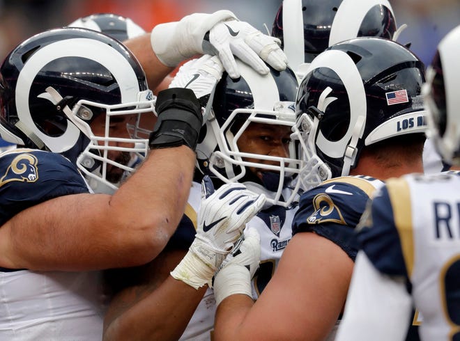 Los Angeles Rams running back Todd Gurley, center, celebrates his touchdown with teammates during the second half of an NFL football game against the Denver Broncos, Sunday, Oct. 14, 2018, in Denver. (AP Photo/David Zalubowski)