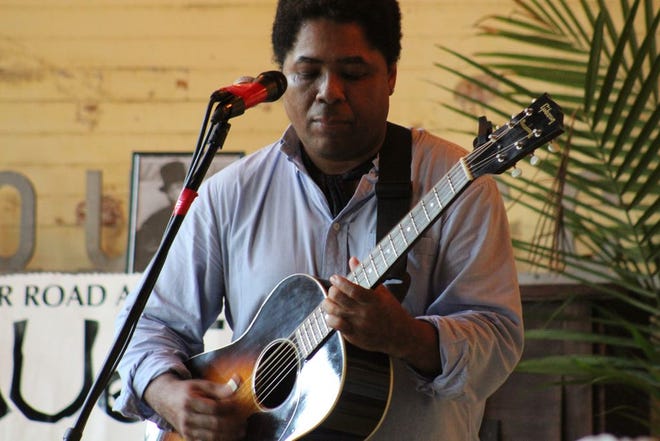 Chris Thomas King performs a song at a recent event held in the River Road African American Museum's Rosenwald School.