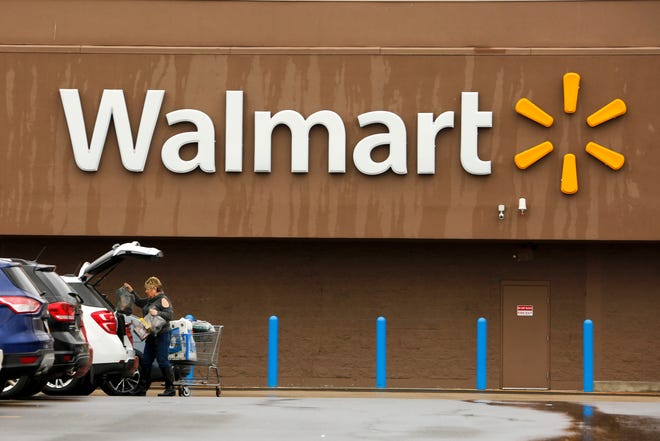 Walmart trimmed its annual profit outlook Tuesday, citing the $16 billion acquisition of the Indian online retailer Flipkart, its biggest deal ever.  [AP ARCHIVE]