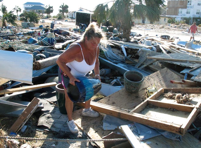 Dena Frost salvages an unbroken clay pot from the wreckage of her pottery business in Mexico Beach on Sunday. [RUSS BYNUM/AP]