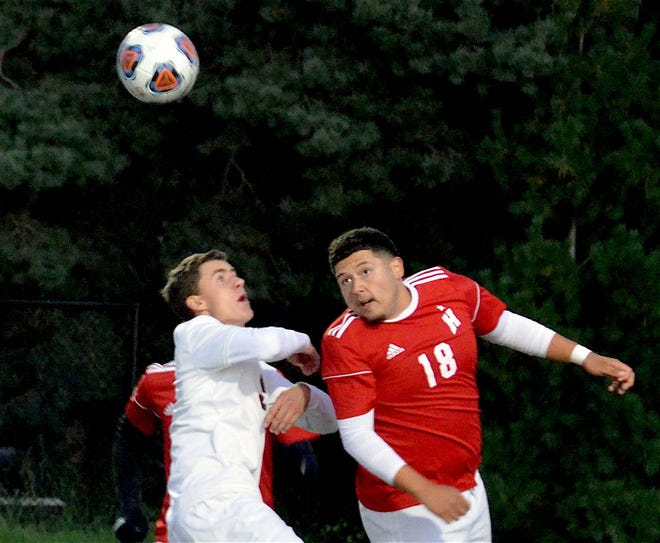 Holland Christian's Jace DeWitt (left) battles for a ball with Holland's Omar Arellano during the district semifinals Thursday at Holland. [Dan D'Addona/Sentinel staff]