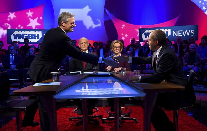 Republican Massachusetts Gov. Charlie Baker, left, shakes hands with Democratic challenger Jay Gonzalez prior to a debate at the studios of WBGH-TV in Boston, Wednesday. At center are hosts Jim Braude and Margery Eagan. (Meredith Nierman/WGBH-TV via AP, Pool)