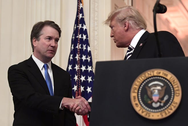 President Donald Trump, right, shakes hands with Supreme Court Justice Brett Kavanaugh, left, before a ceremonial swearing in in the East Room of the White House in Washington, Monday, Oct. 8. [AP Photo/Susan Walsh]