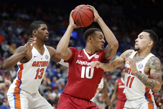 Arkansas' Daniel Gafford (10) tries to squeeze past Florida's Kevarrius Hayes (13) and Chris Chiozza (11) during the first half in the quarterfinals of the Southeastern Conference tournament on March 9 in St. Louis. [AP File Photo/Jeff Roberson]