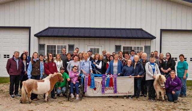Volunteers and members of One Heart Equestrian Therapy come together to celebrate their new permanent home before the program’s open house on Sunday. Contributed photo