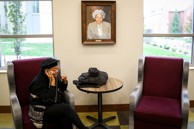 Marcia Berry, a first-year Ph.D. student in the MU Department of Theatre and Drama, speaks on the phone white seated under a portrait of Lucille Bluford in the lobby of Bluford Hall on Friday. The university held a dedication ceremony of a residence hall and atrium to three pioneering African-Americans, including Lucille Bluford, who was denied entrance to MU because of segregation. [Hunter Dyke/Tribune]