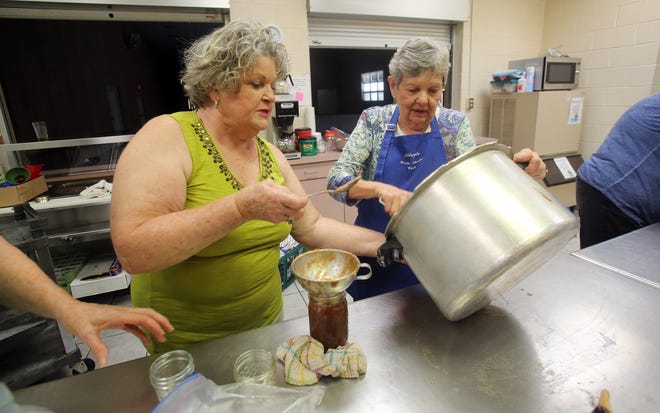 From left, Rose Addington and Mary Henry fill jars with apple butter at Aldersgate United Methodist in Shelby. The annual Apple Butter Festival begins at 9 a.m. Saturday at the church. [Brittany Randolph/The Star]