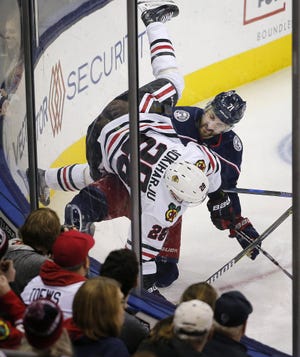 Blackhawks defenseman Henri Jokiharju gets the worst of a collision with Blue Jackets left wing Nick Foligno during the second period. [Adam Cairns/Dispatch]