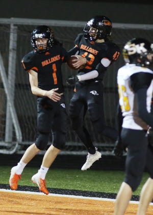 Mediapolis quarterback Cauy Massner (1) celebrates a touchdown with teammate Drayven Fenton (43) in the first quarter of Friday's game against Sigourney-Keota. [John Gaines/thehawkeye.com]
