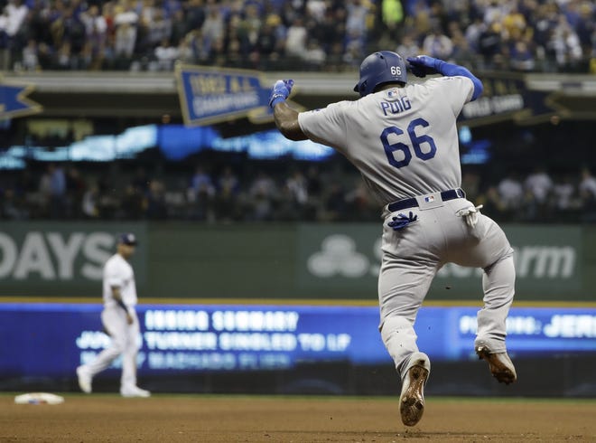 Los Angeles Dodgers' Yasiel Puig reacts after hitting a three-run home run during the sixth inning of Game 7 of the National League Championship Series against the Milwaukee Brewers on Saturday in Milwaukee. [Matt Slocum/The Associated Press]