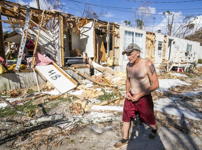 Michael Cannon walks by his home Wednesday in Parker. He rode out Hurricane Michael as it destroyed the home around him. “My family is safe. That’s all that matters,” Cannon said. [DOUG ENGLE/GATEHOUSE MEDIA FLORIDA]