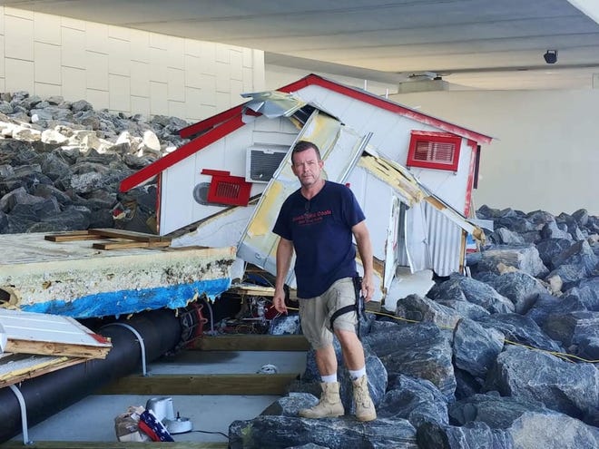 Owner Ernie Hall stands under the Hathaway Bridge with the remains of his floating restaurant, Just the Cook. [CONTRIBUTED PHOTO]