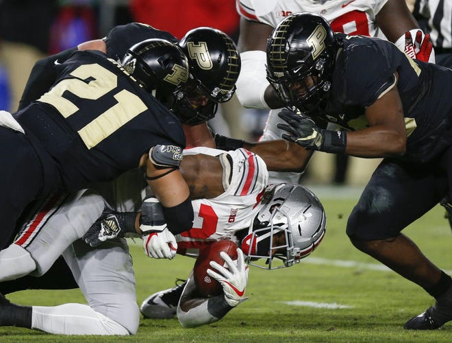 Purdue defenders bring down Ohio State running back Mike Weber during Saturday's game. The lack of a running threat made it difficult for the Buckeyes to move the ball in the red zone. [Joshua A. Bickel/Dispatch]