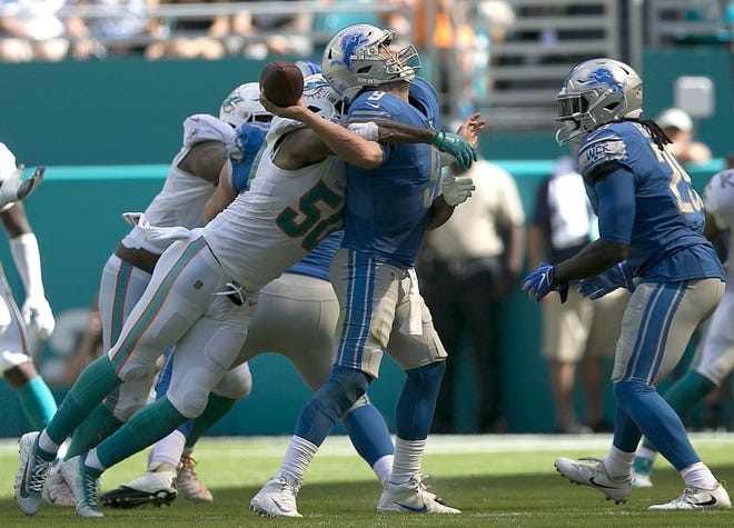 Detroit Lions quarterback Matthew Stafford (9), is hit from behind by Miami Dolphins defensive end Andre Branch (50), causing a fumble and the loss of eight yards during second quarter action of their NFL game Sunday Oct. 21, 2018, in Miami Gardens. [BILL INGRAM/pbpost.com]