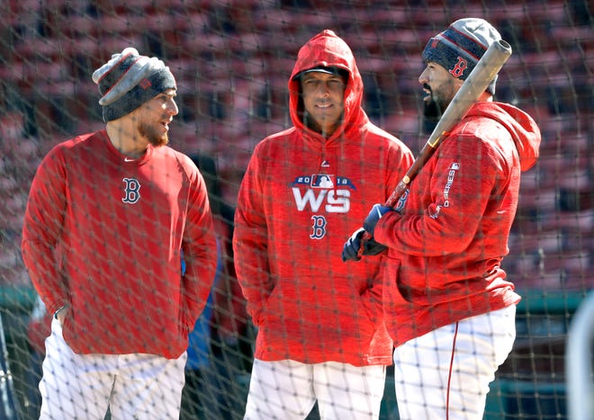 Boston Red Sox manager Alex Cora, middle, chats with catchers, Christian Vazquez, left, and Sandy Leon, right, during a baseball work out at Fenway Park, Sunday, Oct. 21, 2018, in Boston. The Red Sox are preparing for Game 1 of the baseball World Series against the Los Angeles Dodgers scheduled for Tuesday in Boston. (AP Photo/Elise Amendola)