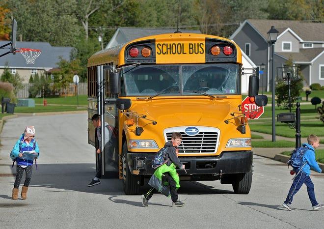 School children get off a Fort LeBoeuf School District bus in Summit Township on Thursday. All Fort LeBoeuf School District buses have video cameras that automatically record images whenever the bus stops to pick up or drop off students. [CHRISTOPHER MILLETTE/ERIE TIMES-NEWS]
