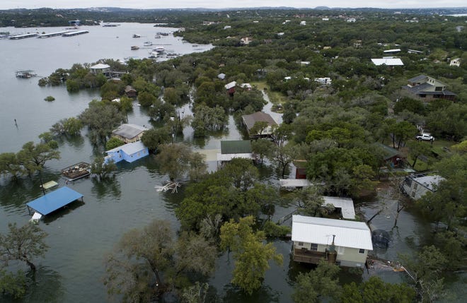 Houses are flooded at Graveyard Point on Lake Travis Wednesday, Oct. 17, 2018, in Austin, Texas. (Jay Janner /Austin American-Statesman via AP)