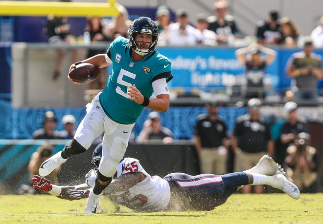 Jacksonville Jaguars quarterback Blake Bortles (5) scrambles to the right avoiding a tackle by Houston Texans linebacker Benardrick McKinney (55) during the first half of an NFL football at TIAA Bank Field in Jacksonville, Fla., Sunday, Oct. 21, 2018. [For The Florida Times-Union/Gary Lloyd McCullough]