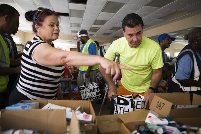 People displaced from their homes and who have lost their jobs get free food, sanitary items and cleaning supplies at Jinks Middle School on Friday. [JOSHUA BOUCHER/THE NEWS HERALD]