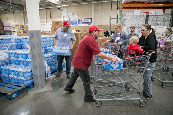 Employees load bottles of water Tuesday for customers at Costco in Southwest Austin during a citywide boil water notice. [JAY JANNER/AMERICAN-STATESMAN]